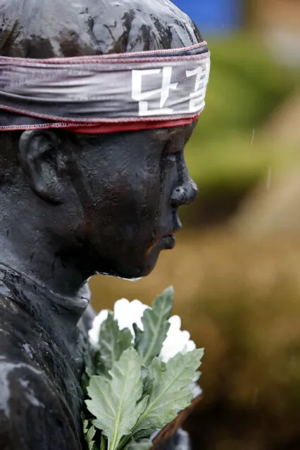 Rain drips like tears over a statue of Jeon Tae-il