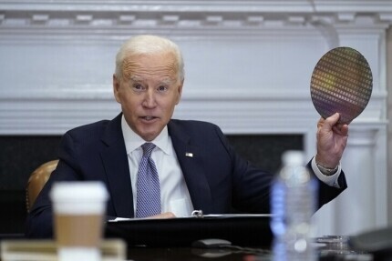 US President Joe Biden holds up a silicon wafer while speaking during the virtual CEO Summit on Semiconductor and Supply Chain Resilience from the White House, April 12, 2021. (AP/Yonhap News)
