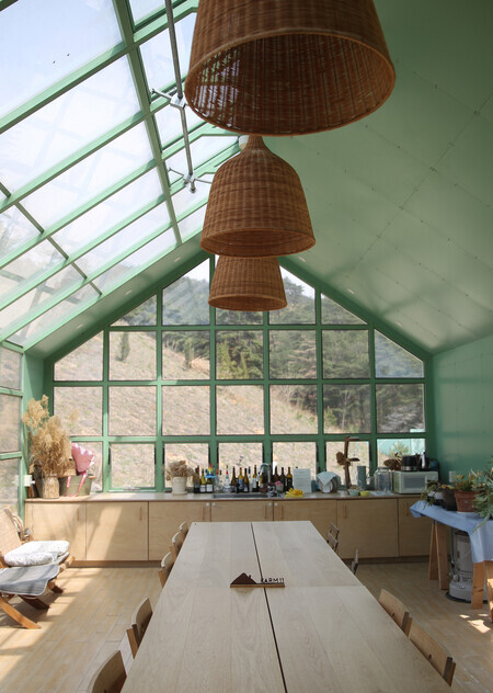 Farm11’s windowed greenhouse offers a great view of the hillside and forest. (Park Mee-hyang/The Hankyoreh)