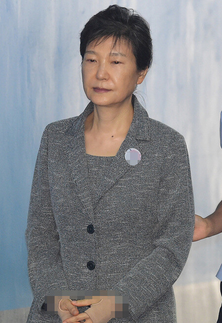 Former President Park Geun-hye enters the courtroom in the Seoul Central District Court to continue her trial on bribery and corruption charges on Aug. 25. (Photo pool)