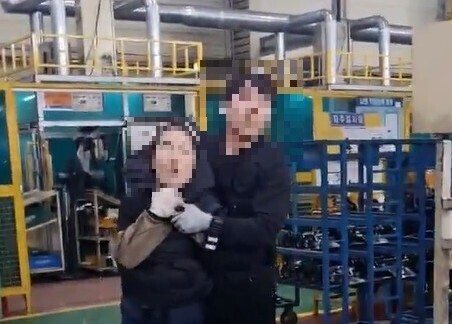 A Ministry of Justice worker puts a migrant worker woman in a headlock during a crackdown on undocumented migrants at a factory in Gyeongju, North Gyeongsang Province, on Nov. 7. (still from video)