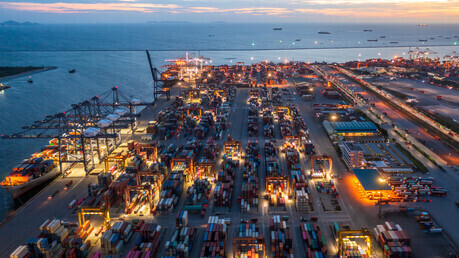 Lights illuminate a port filled with shipping containers. (Getty Images Bank)