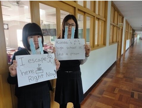 Students hold placards expressing their feelings about living as youths in South Korea
