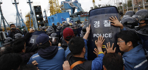 Laid-off workers from Hanjin Heavy Industries and Construction (HHIC) struggle with riot police officers to prevent the arrest of Kim Jin-suk in front of Crane No. 85 in HHIC’s Youngdo shipyard in Busan, Nov. 9, 2011. (Kim Myoung-jin/The Hankyoreh)