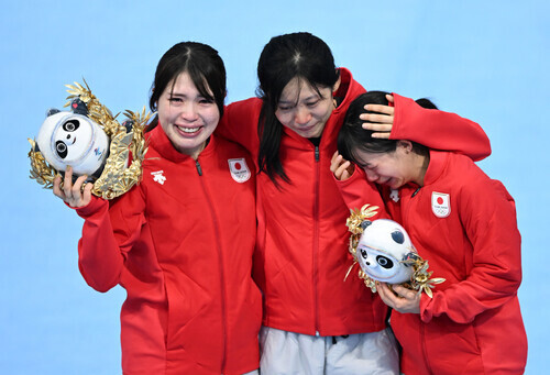 Members of Japan’s pursuit speedskating team (from left to right) Ayana Sato, Miho Takagi and Nana Takagi are seen crying on the podium after coming in second following a slip and fall by Nana Takagi just before the finish line in their event on Tuesday. (Xinhua/Yonhap News)