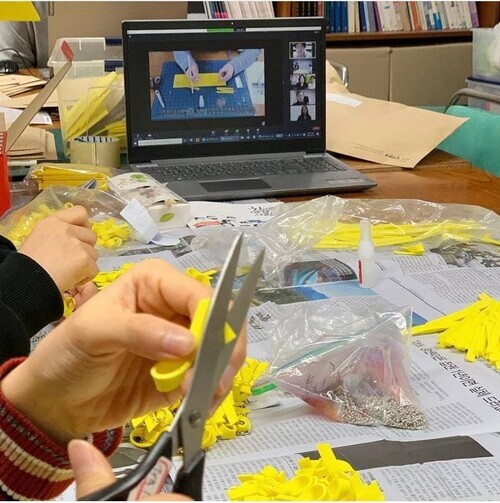 Volunteers make yellow ribbons at a workshop in Seoul’s Seochon neighborhood. (provided by People’s Solidarity for Participatory Democracy)