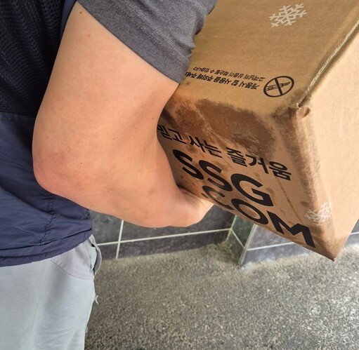 2025년 7월22일 서울 강서구의 한 아파트에서 기사 ㄱ씨가 택배를 꺼내고 있다. 아이스팩이 녹아 상자가 다 젖은 모습이다. 신다은 기자