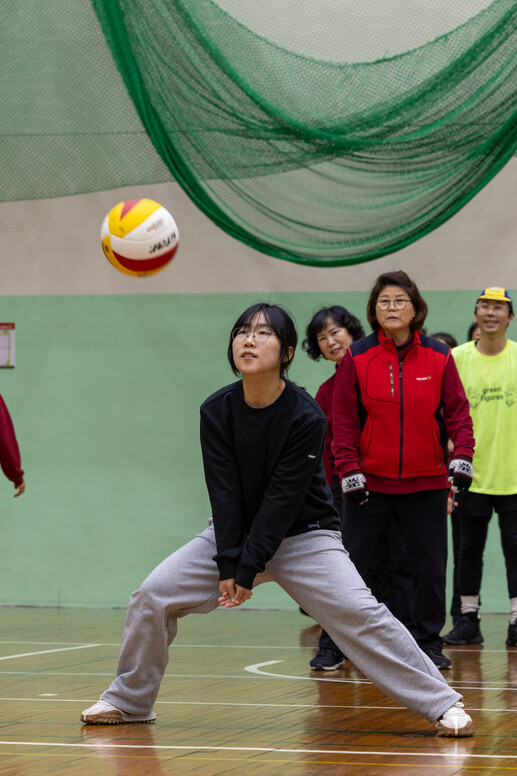 청소노동자들과 함께 배구 수업을 듣는 서강대학생이 날아오는 공을 치기 위해 자세를 잡고 있다.