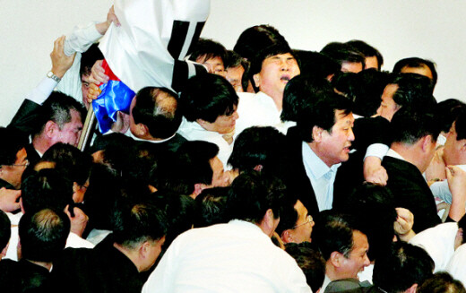  stands surrounded by GNP lawmakers and Assembly guards just before banging a gavel to declare the  passage of the 2011 budget.   (Photo by Tak Ki-hyoung)　
