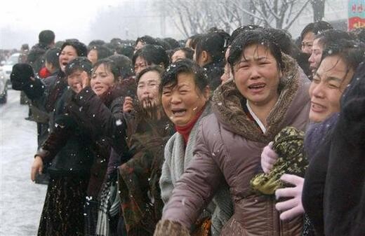 People cry out as a procession of a hearse carrying the late North Korean leader Kim Jong-il‘s coffin passes through the streets of Pyongyang amid snowfall on Dec. 28.
(Kyodo Yonhap)