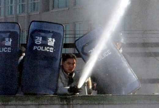  a man presumed to be a security guard shoots a water cannon at protesters to disperse them from a building where they were demonstrating against a Yongsan redevelopment project on January 19.
