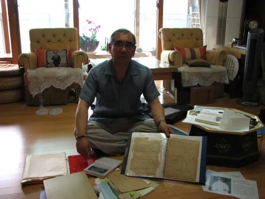  the president of the National Korean War Surviving Family Members’ Association shows a picture of his grandfather and father’s documents at his home.
