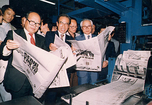 Inaugural Executive Editor Lim Jae-kyung (front left) holds the first edition of the Hankyoreh fresh off the printers on May 14, 1988. (Hankyoreh archives)