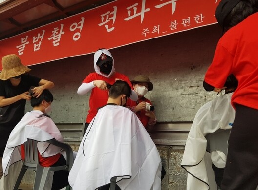 Women at a demonstration organized by the internet café called “Uncomfortable Courage” in front of Hyehwa Station on June 9 partake in a head-shaving ceremony to protest societal prejudices against women.