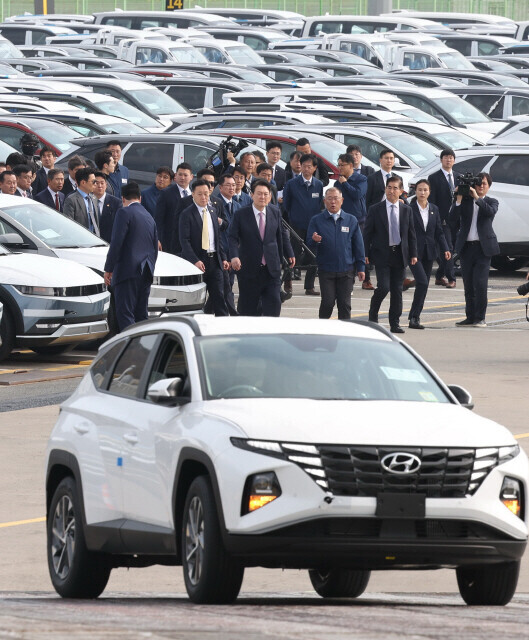 President Yoon Suk-yeol and Hyundai Motor Chairperson Chung Eui-sun walk through a port filled with Hyundai cars for export on April 9. (presidential office pool photo)