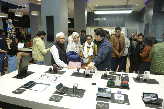 A worker at a Samsung store in New Delhi, India, introduces shoppers to mobile phone products. (courtesy of Samsung Electronics)