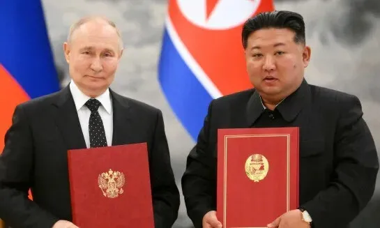 Russian President Vladimir Putin (left) and North Korean leader Kim Jong-un stand for a photo with copies of their newly signed pact establishing a comprehensive strategic partnership between their two nations following their summit in Pyongyang, North Korea, on June 19, 2024. (TASS/Yonhap)