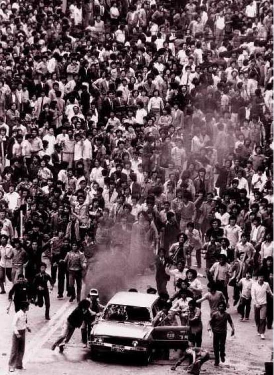 Demonstrators push a car on fire toward the martial law forces. (May 18 Memorial Foundation)