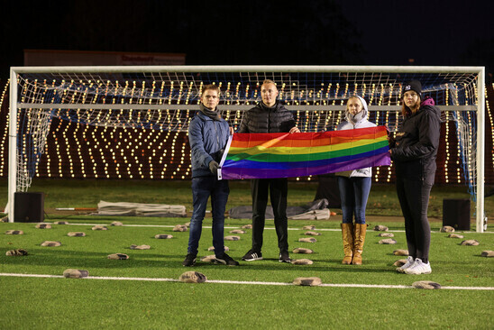 People hold a rainbow flag in support of LGBTQ rights on the field at Stadion am Schloss Strunkede in Herne, Germany, on Nov. 21. (Reuters/Yonhap)