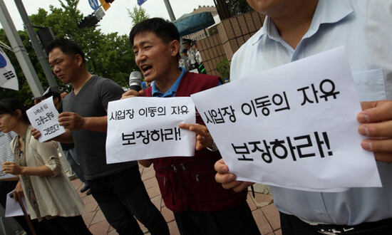  holds a demonstration in front of Gwacheon Government Complex on July 17. Theirs signs ask for migrant workers to have the freedom to change workplaces. (by Park Jong-shik