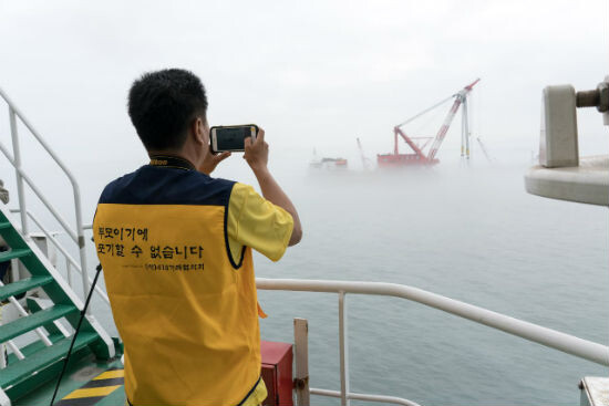 A family member of one student who died in the Sewol ferry sinking watches the ongoing efforts to raise the ferry