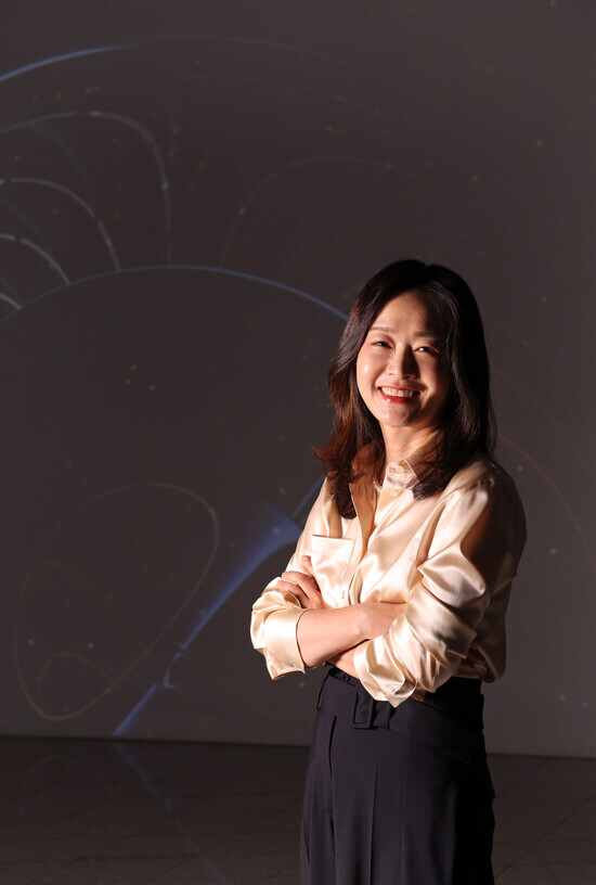 Yoon Songyee, CSO of NCSOFT, smiles for the camera in front of “Graphic Processor” (by Shim Q-ha) displayed at Dongdaemun Design Plaza’s media art gallery on June 15. (Lee Jeong-yong/The Hankyoreh)