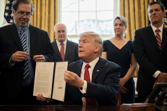 US President Donald Trump holds up an executive order that he signed at the White House on April 20 authorizing an investigation into whether steel imports from South Korea