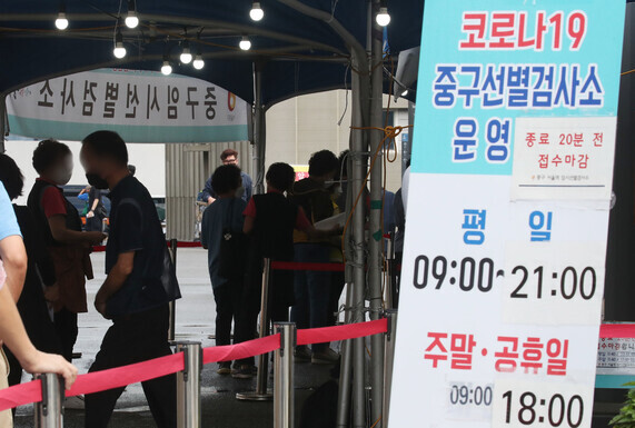 People wait in line to get tested for COVID-19 at a temporary screening station in Seoul on Wednesday. (Yonhap News)