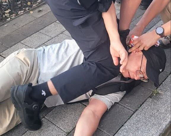 2026년 9월3일 서울 용산구 드래곤시티 호텔 인근 도로변에서 경찰관이 무릎으로 김남규 ‘비정규직이제그만’ 활동가의 목을 누르고 있다. 엔딩크레딧 제공