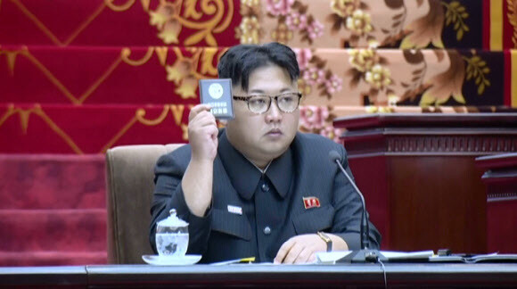 An image of North Korean leader Kim Jong-un votes with his party member card during a meeting of the Supreme People’s Assembly in Pyongyang on June 29