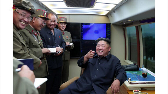 North Korean leader Kim Jong-un smiles after observing the test launch of a short-range projectile near Hamhung
