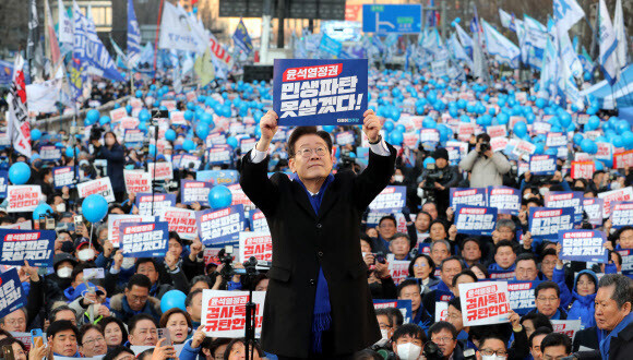Lee Jae-myung, leader of the Democratic Party, holds up a picket condemning the Yoon administration during a rally held by his party near Seoul’s Sungnye Gate in the city center on Feb. 4. (pool photo)