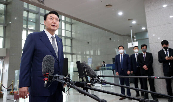 President Yoon Suk-yeol answers questions from reporters while commuting to his office on June 24. (presidential office pool photo)
