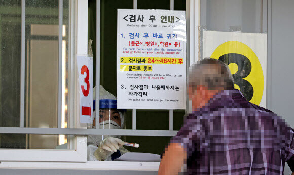 A Seoul resident in the process of getting tested at a screening clinic in Seoul’s Seongbuk District on Aug. 24. (Yonhap News)