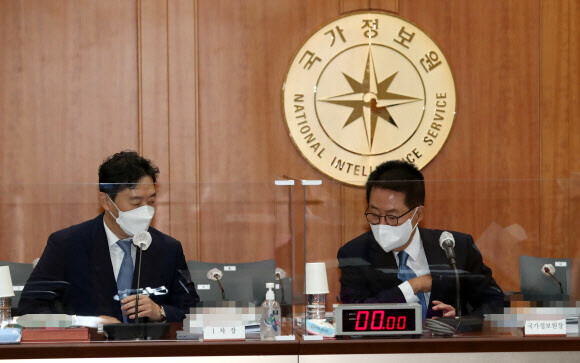 National Intelligence Service Director Park Jie-won (right) speaks with NIS Deputy Director Kim Hyeong-jung during a parliamentary audit of the agency on Thursday. (Yonhap News)