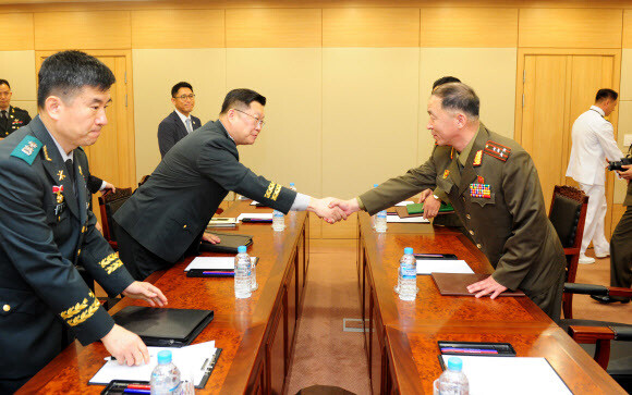 South and North Korean military offices shake hands before discussing the resumption of marine radio communications during talks at the Customs