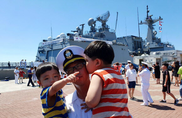 A naval officer poses for a family photo before the ROKS Kang Gam Chan