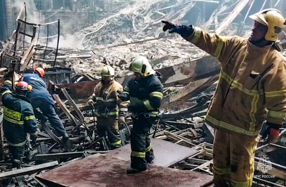 Emergency workers clear rubble after a terror attack and explosion at Crocus City Hall on the outskirts of Moscow on March 22, 2024 (local time). (TASS/Yonhap)
