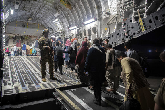 Afghans board a US Air Force C-17 Globemaster III transport plane during an evacuation at Hamid Karzai International Airport in Kabul, Afghanistan, on Sunday. (provided by the US Air Force)
