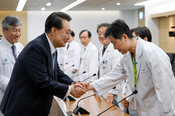 President Yoon Suk-yeol greets doctors at a roundtable held at Asan Medical Center in Seoul’s Songpa District on March 18, 2024. (courtesy of the presidential office/Yonhap)