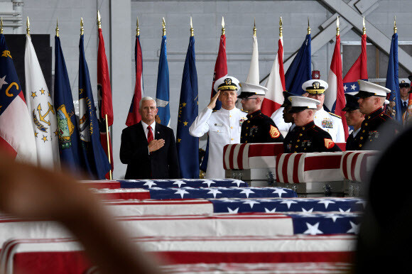 The remains of 55 US POW/MIA arrive at the US Joint Base Pearl Harbor–Hickam in Hawaii on Aug. 1. US Vice President Mike Pence (left) and Admiral Philip Davidson