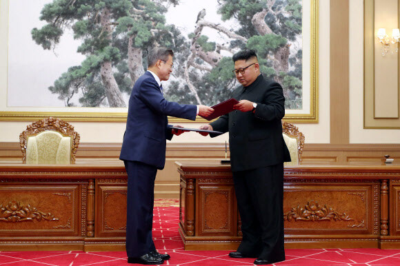 South Korean President Moon Jae-in exchanges documents with North Korean leader Kim Jong Un during a signing ceremony after their summit at Paekhwawon State Guesthouse in Pyongyang on September 19