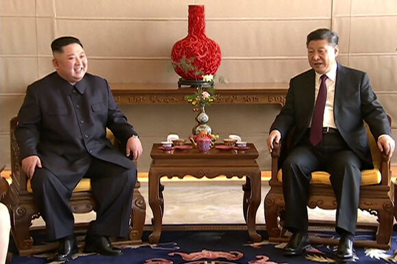 North Korean leader Kim Jong-un and Chinese President Xi Jinping talk before their luncheon at the Beijing Hotel on Jan. 9. (Beijing/AFP)