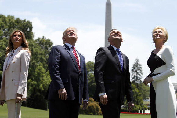 US President Donald Trump and first lady Melania Trump watch as F-35 fighter jets pass the White House with Polish President Andrzej Duda and first lady Agata Kornhauser-Duda on June 12. (AP/Yonhap News)