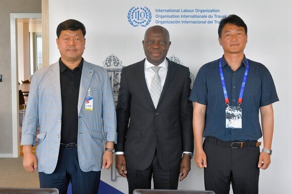 Gilbert F. Houngbo, director-general of the International Labour Organization, stands with Yang Kyeung-soo (right), leader of the Korean Confederation of Trade Unions, and Ryu Ki-seop, secretary-general of the Federation of Korean Trade Unions.