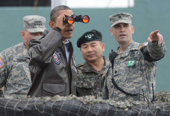 U.S. President Barack Obama visits the observation post Ouellette in the DMZ near Panmunjom Joint Security Area. Obama looks to the North Korean side through a telescope while listening to a briefing by Lt. Colonel Edward Taylor