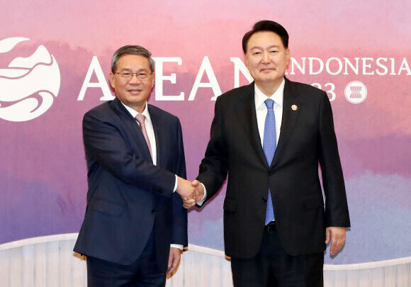 President Yoon Suk-yeol of South Korea poses for a photo with Chinese Premier Li Qiang to mark their summit on the sidelines of the ASEAN summit in Indonesia. (Yonhap)