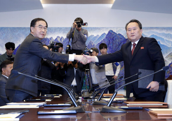 South Korean Minister of Unification Cho Myoung-gyon (right) and North Korean Committee for the Peaceful Reunification of the Fatherland Chairman Ri Son-gwon shake hands after exchanging copies of their signed joint statements as they conclude high-level inter-Korean talks at the House of Peace in Panmunjom on Oct. 15. (photo pool)