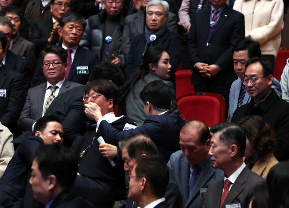 Kang Sung-hee, a lawmaker with the minor Progressive Party, is dragged away by security guards after shaking hands with President Yoon Suk-yeol during an event celebrating the promotion of North Jeolla Province to “state” status on Jan. 18. (Yonhap)
