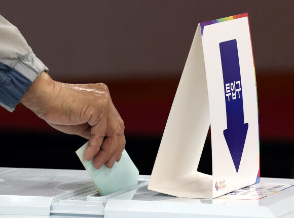 A voter slips their ballot into the ballot box at a polling station in Seoul on June 1, the date of South Korea’s eighth local elections. (Yonhap News)